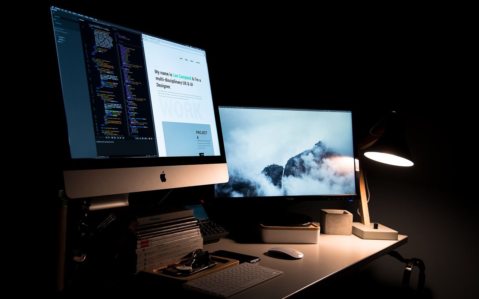 Qaranlıq studiyada iki monitorlu dizayner iş yeri