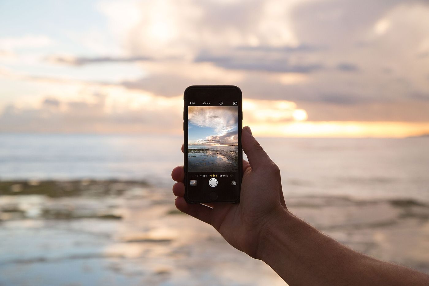 Gün batımında əldə tutulan smartfon