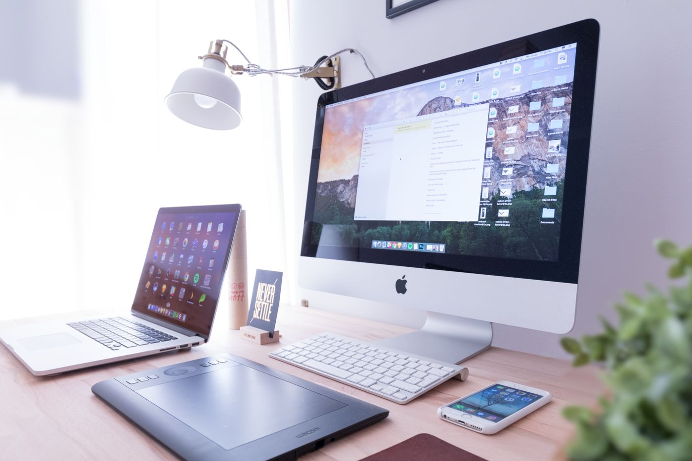 Ağ masada iMac, planşet və smartfon