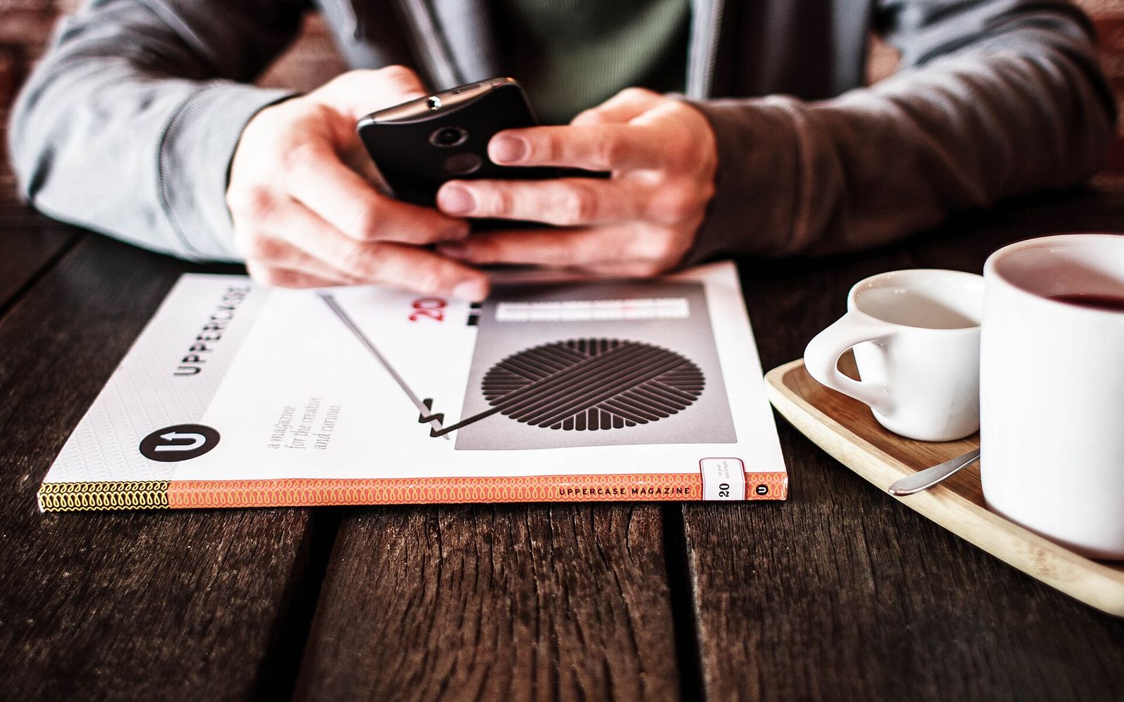 Qəhvə masasında smartfon tutan əllər